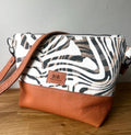 Handcrafted leather and denim cross body bag